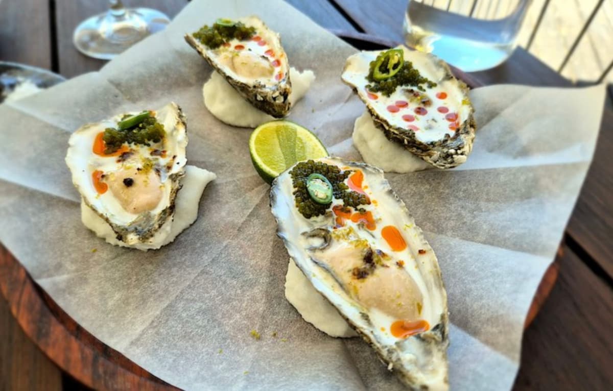 Four oysters at Chef's Warehouse at Beau Constantia — dressed with green-strawberry granita, salmon roe, jalapeño and lime, on the wine-bar deck