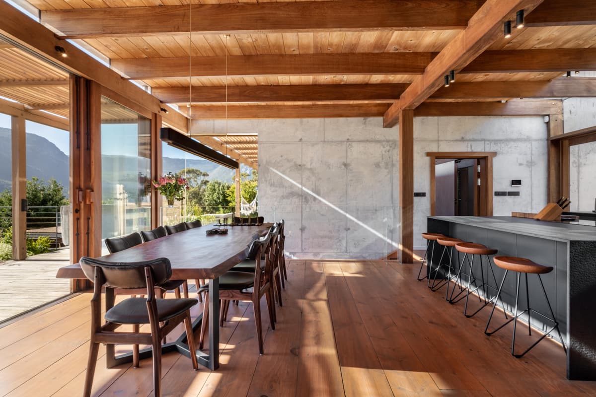 The dining table laid under the slatted Saligna pine ceiling