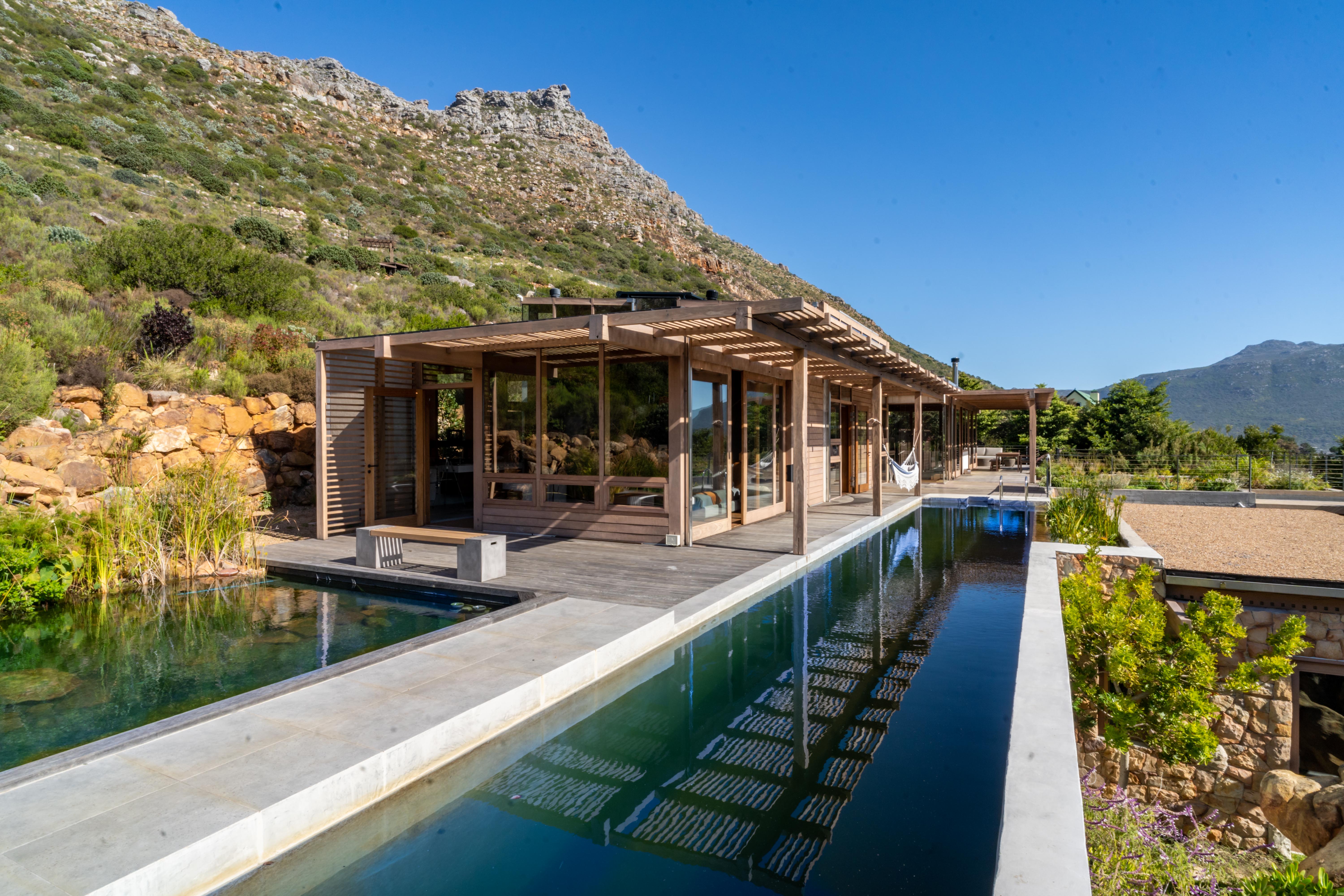 Wraparound deck above the 20-metre lap pool, looking across Hout Bay valley with the mountain ridge to the right.