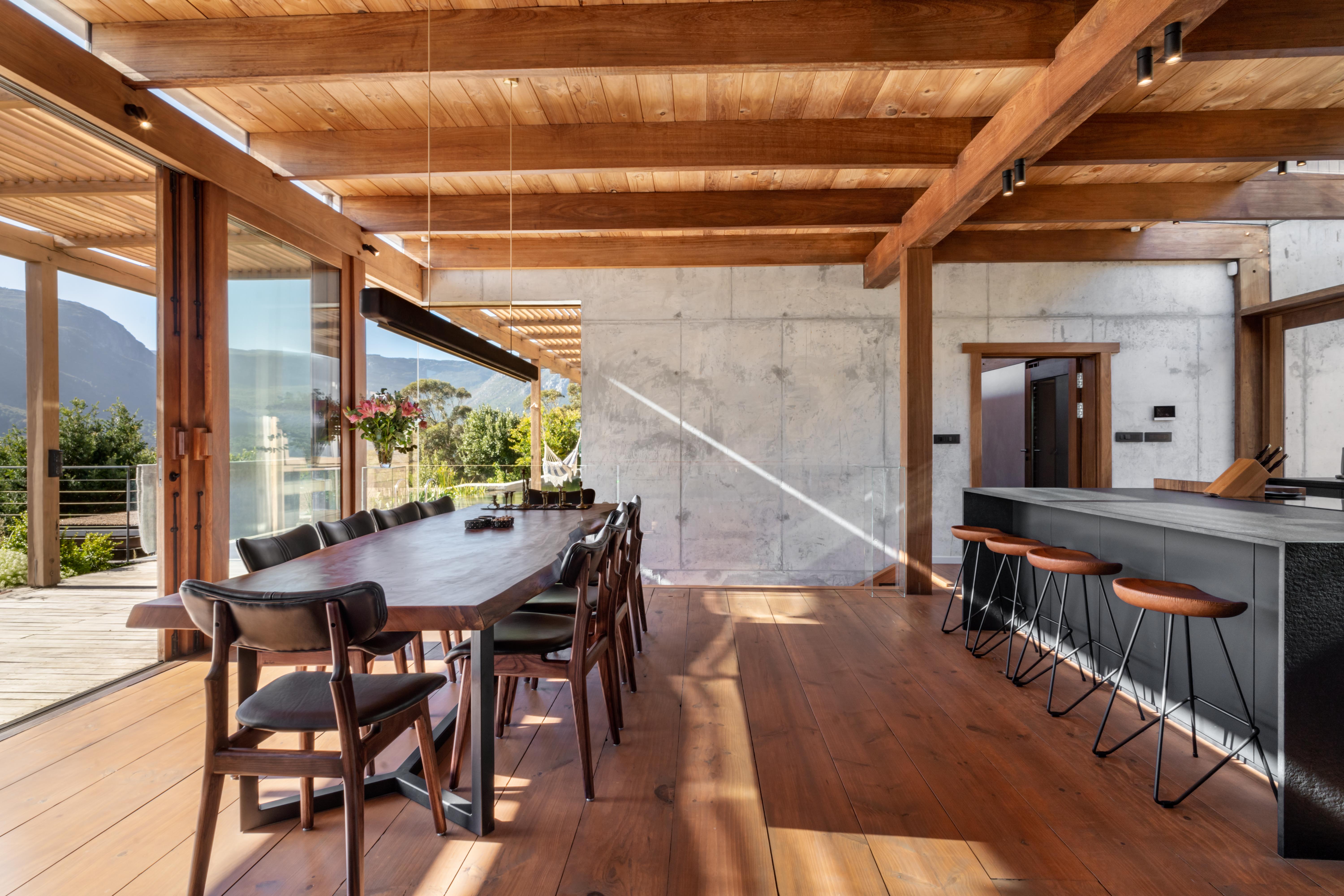 The dining table laid under the slatted Saligna pine ceiling