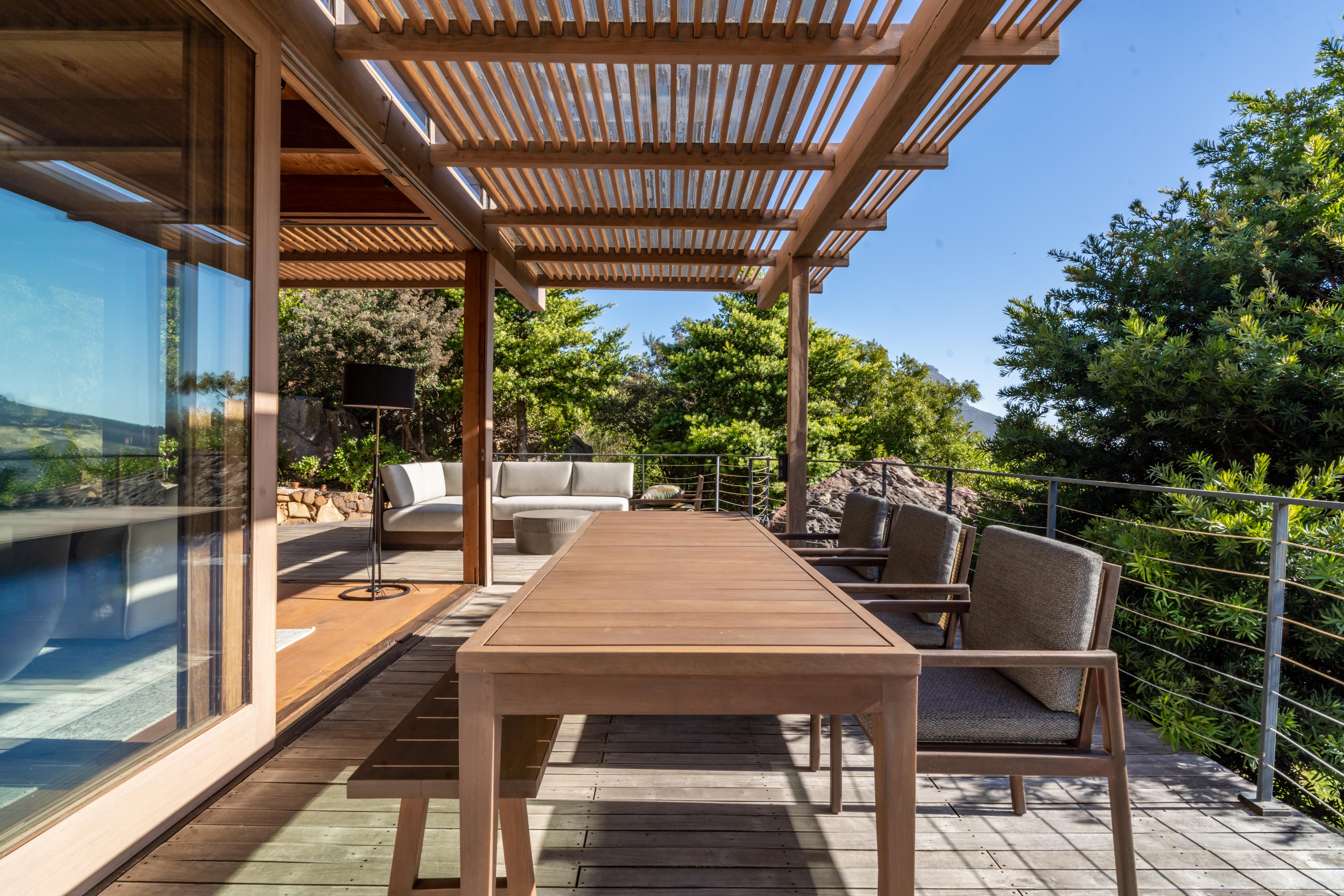 The outdoor dining table set above the Hout Bay valley, Table Mountain beyond.